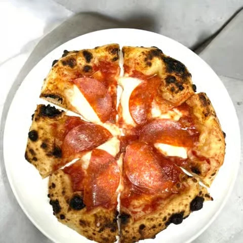 A pepperoni pizza with a charred crust